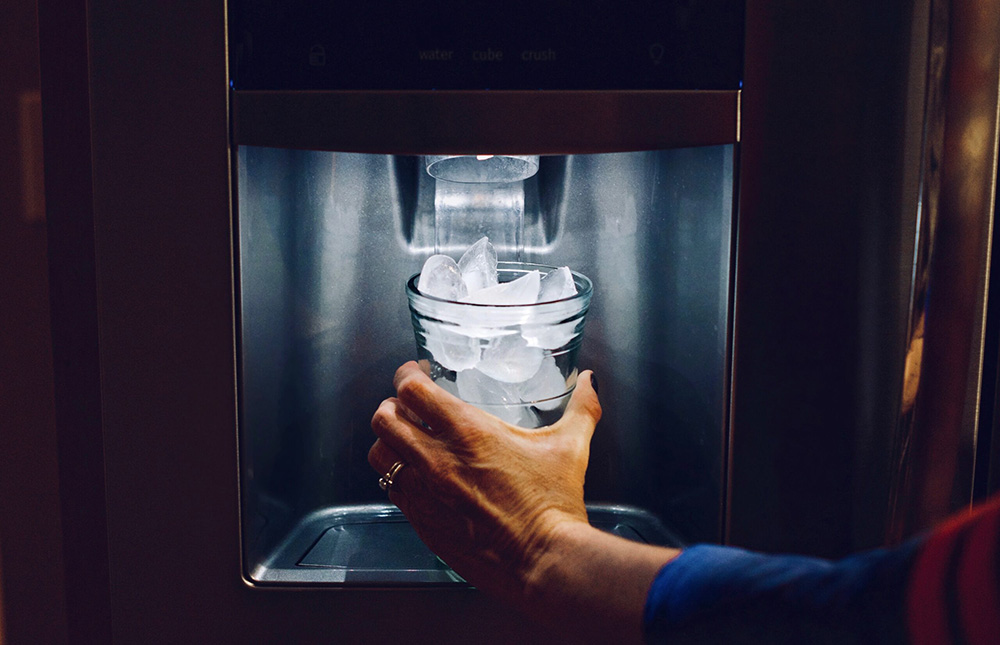 A person taking ice from the ice machine - boise geothermal services by innovative mechanical solutions